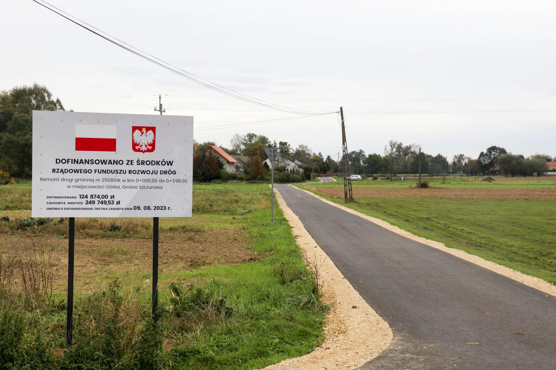 Na zdjęciu znajduję się droga z tablicą informacyjną. 