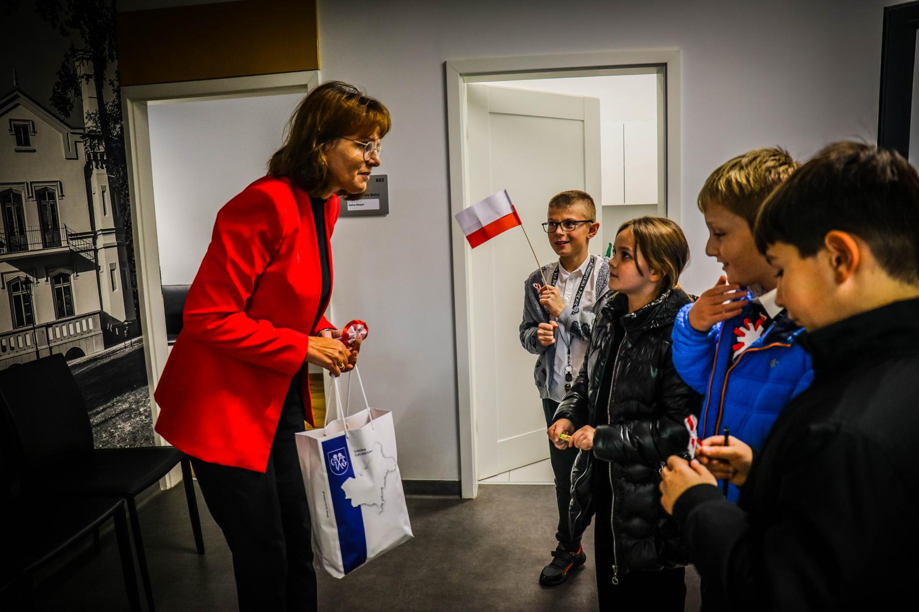 Na zdjęciu znajduje się p. wójt Halina Święch przekazująca dzieciom upominek