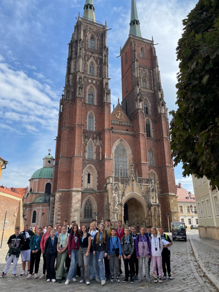 Dzieci pozujące do zdjęcia na tle katedry wrocławskiej